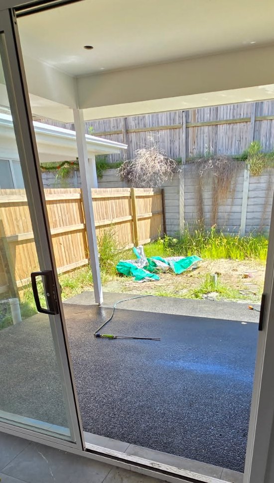 Charcoal exposed aggregate alfresco slab meeting the sliding door threshold, Sunshine Coast