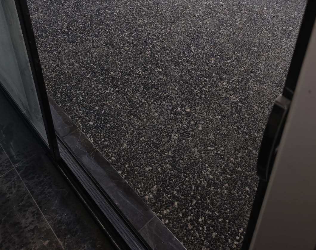 Close view of charcoal exposed aggregate at an alfresco threshold, Sunshine Coast